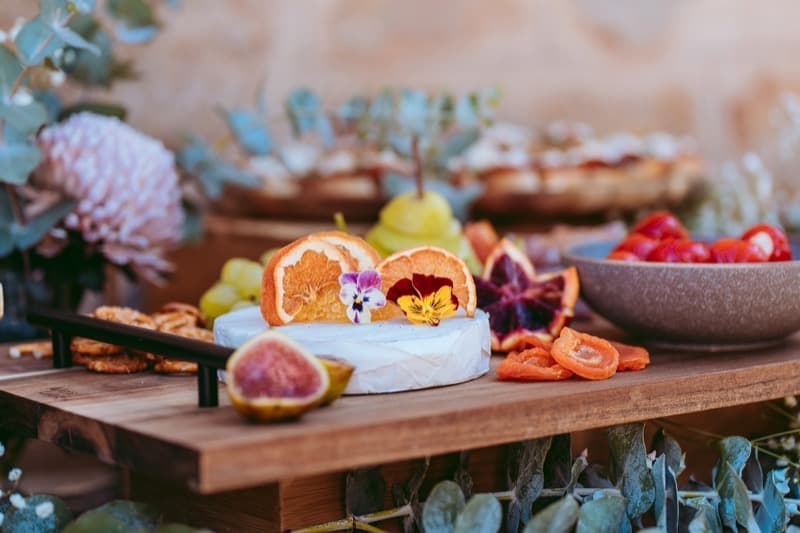 Close-up of artisan brie with edible flowers on an Adelaide grazing board