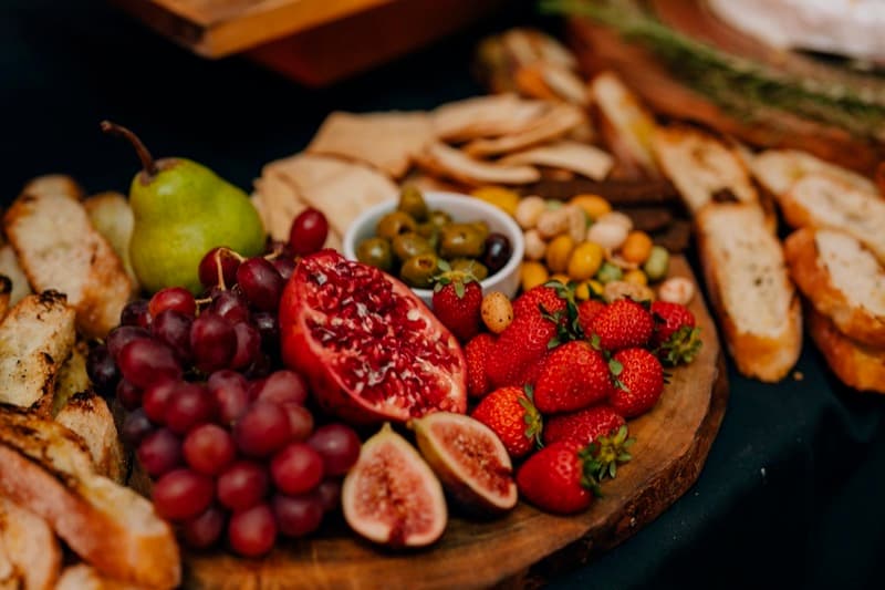 Adelaide grazing board with pomegranate, figs, and seasonal fruit