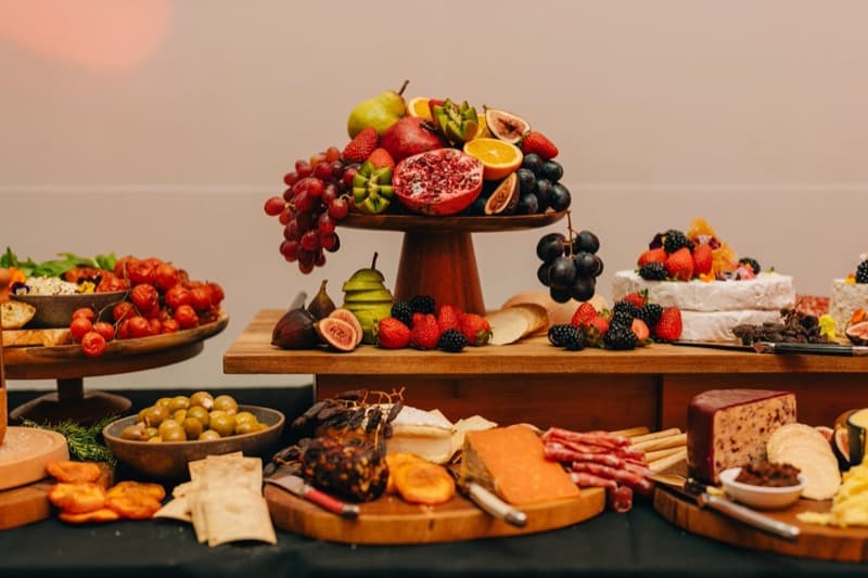Stunning grazing table centrepiece with seasonal fruits on a wooden pedestal stand at an Adelaide private event